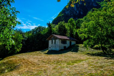 İtalya 'nın Trento kentindeki Ledro Gölü' nde taze kesilmiş çimen çayırlarıyla Alplerdeki tipik bir alet kulübesi.