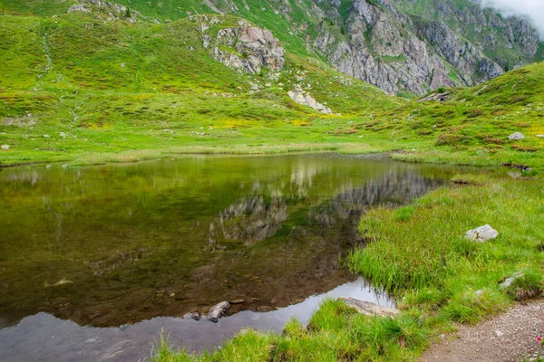 Маленькое Чистое Альпийское Озеро Отражает Горы Вокруг Себя Великолепной Обстановке — стоковое фото