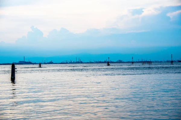 the industrial area of Marghera against the backdrop of a still lagoon in a summer twilight in Venice, Italy