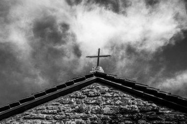 San Michele Arcangelo Kilisesi 'nin çatısında mavi gökyüzü ve beyaz bulutlara karşı Chiusi Della Verna, Arezzo, Toskana, İtalya