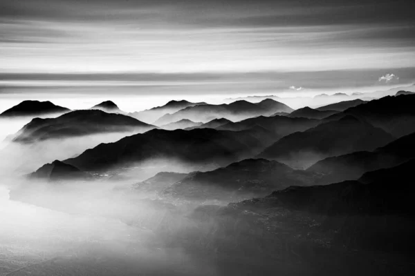 阿尔卑斯山的山峰环绕着加尔达湖 周围笼罩着浓雾 蓝天环绕着意大利特伦托的阿尔蒂西莫山 — 图库照片