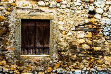Castegnero, Vicenza, Veneto, İtalya 'da taş duvardaki eski ahşap panjurlarla kapatılmış eski pencere.