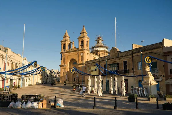 Marsaxlokk, Malta, Ağustos 2019. Sabahın erken saatlerinde katedral ile köyün ana meydanı.