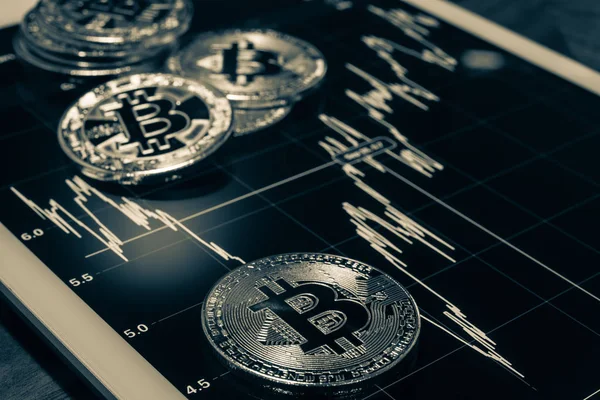 Cryptocurrency, o gösteren Fiyat veya borsa performans grafiği, koyu tonu siyah beyaz filtre tablet ekranda oturum odak Bitcoin. Adem-i merkeziyetçi, blockchain üzerinden dijital para transferi.