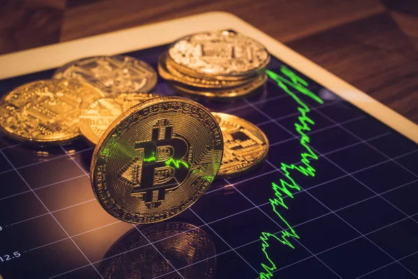 Cryptocurrency, ışık gösteren yansıtacak yeşil Fiyat veya borsa performans grafiği, koyu tonu tablet ekran Bitcoin odaklanmak. Adem-i merkeziyetçi transfer exchange dijital para ile blockchain.