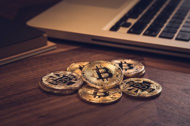 Yeni altın Bitcoins ahşap masa üzerinde. Defter ve kitap karanlık oda ışık ile arka plan. Modern iş tarzı, kavramları blockchain, cryptocurrency, dijital döviz ve yatırım için fon.