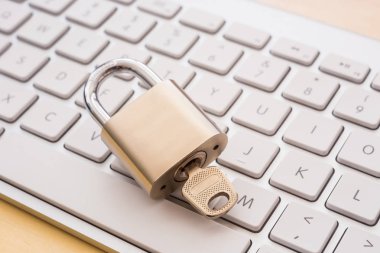 Beyaz klavyeden, arka plan üzerinde ahşap masa ile Metal asma kilit kapatın. Dijital veri koruma, şifreleme, internet erişimi, siber ağ, iş çözümü, blockchain güvenlik kavramları.