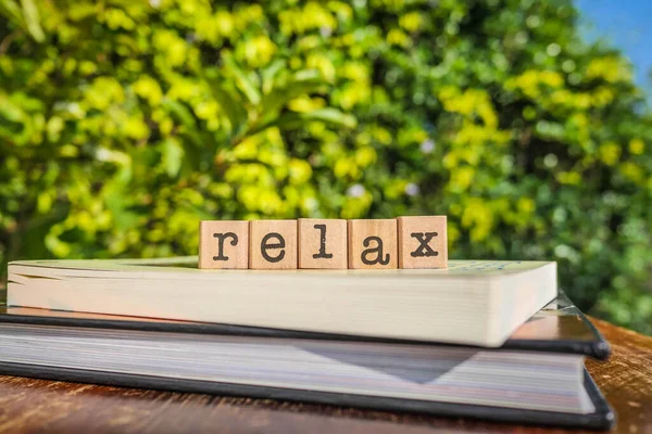 Das Wort Relax Buchstaben Auf Blockwürfeln Auf Büchern Und Holztischen — Stockfoto