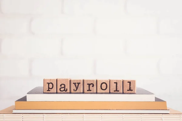 Payroll という言葉 レンガの背景を持つ本の上に木製のキューブ上の文字 空白のコピースペース ヴィンテージ最小限のスタイル 人的資源 従業員への支払い ビジネスの概念 — ストック写真