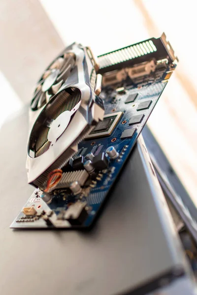 Στοιχεία ενός προσωπικού επιτραπέζιου υπολογιστή μια κάρτα βίντεο αποσυναρμολογημένη πλακέτα με ένα ψύκτη βρίσκεται στην περίπτωση ενός προσωπικού υπολογιστή — Φωτογραφία Αρχείου