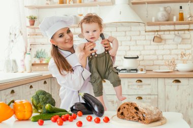 Genç bir anne oğluyla bir aile yemeği hazırlarken mutfaktaki,