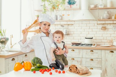 Genç bir anne oğluyla bir aile yemeği hazırlarken mutfaktaki,