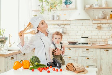 Genç bir anne oğluyla bir aile yemeği hazırlarken mutfaktaki,