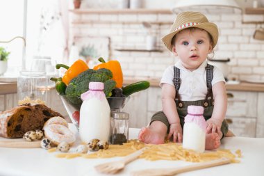 küçük oğlan sebze ve süt ile mutfak masasında oturuyor