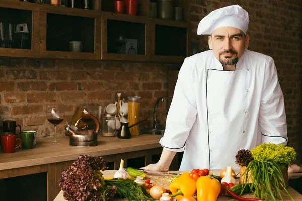 mutfakta yemek pişirmek için tablo taze sebze üzerinde genç şef