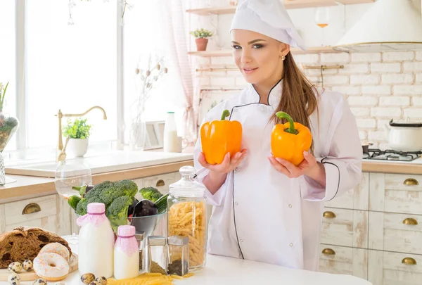 kadın şef mutfakta, masaya yiyecek bolluğu