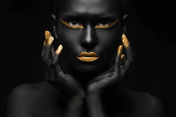 black background and black woman with chic gold makeup
