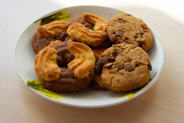 The photo of a pile of chocolate chip cookies and shortcake biscuits on the plate. National Cookie Day background