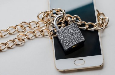 Engellenmiş akıllı telefon. Akıllı telefon, yazılıma özel erişimin bir sembolü olarak zincirlenmiş ve kilitlenmiştir