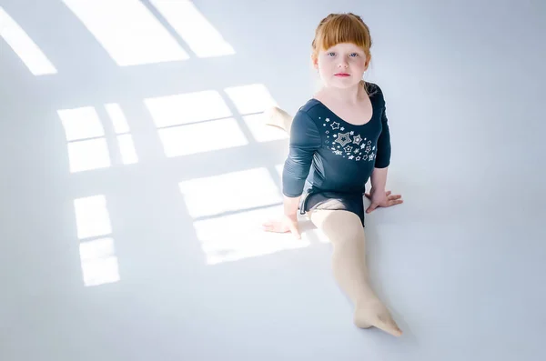 Menina executa um cordel de ginástica no estúdio em um branco — Fotografia de Stock