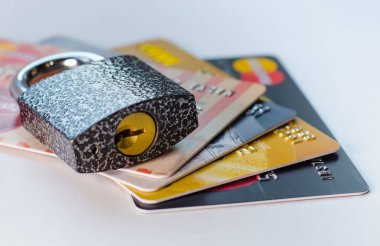 Bloke edilmiş bir banka kartı. Kredi kartı hesabı bloke edildi. Kartüzerinde işlem yapmak mümkün değildir. Zincirde ve kilit altında kredi kartları ve anahtar.