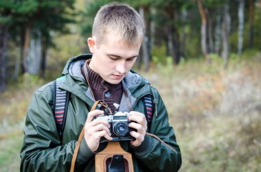 Ormanda bir retro kamera ile bir adam bir çerçeve yapmaya hazırlanıyor