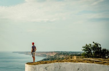 Gün batımında sahilde duran adam.