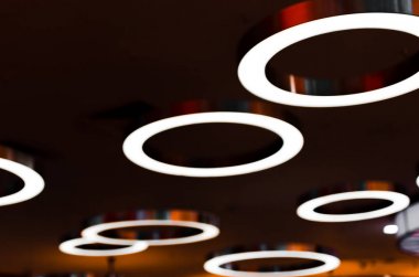 Parlak bir ışık ile büyük halkalar şeklinde unfocus fikstür. Işıklı lambaların arka plan resmi.