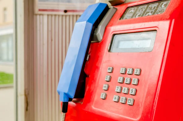 Uma cabine telefónica na rua. Telefone botão vermelho ao longo da estrada para chamadas — Fotografia de Stock