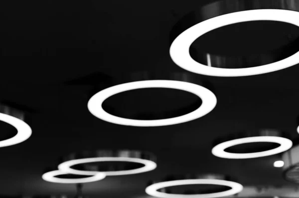 Accesorios en el desenfoque en forma de anillos grandes con una luz brillante. Imagen de fondo de lámparas luminosas . — Foto de Stock