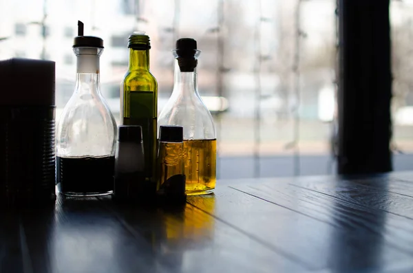 Bottles with sauces and oils for pizza and pasta, standing on the table in the restaurant