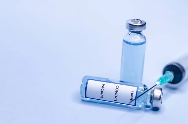 Koronavirová Vakcína Skleněných Injekčních Lahvičkách Injekční Stříkačkou Modrém Pozadí — Stock fotografie