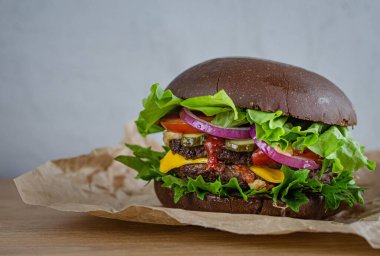 Çavdar ekmeğine sığır eti ve sebzeli sulu güçlü hamburger.