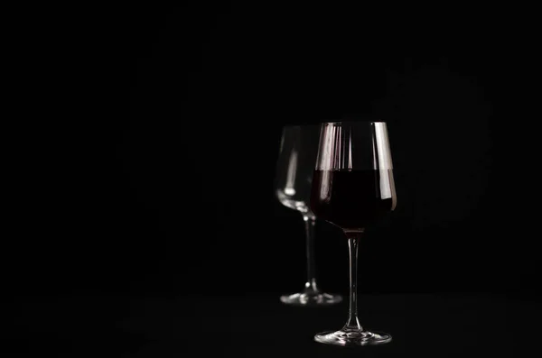 glasses with red wine on a dark background. photograph of wine in a low key