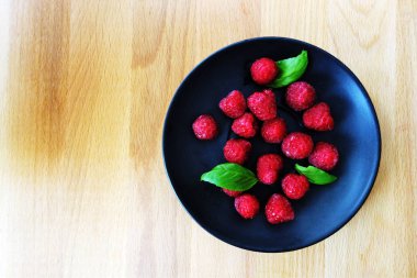 siyah plaka ve ahşap tahta düz yatıyordu taze çilek