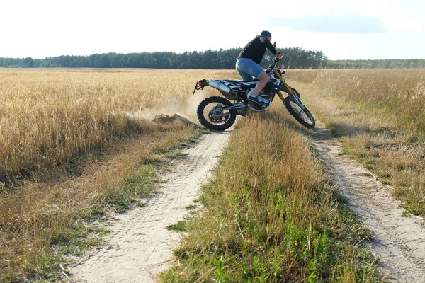 田舎道でクロスバイクに乗っている男 — ストック写真