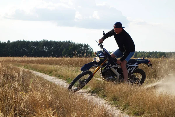 Mann auf Landstraße mit Cross-Motorrad unterwegs — Stockfoto