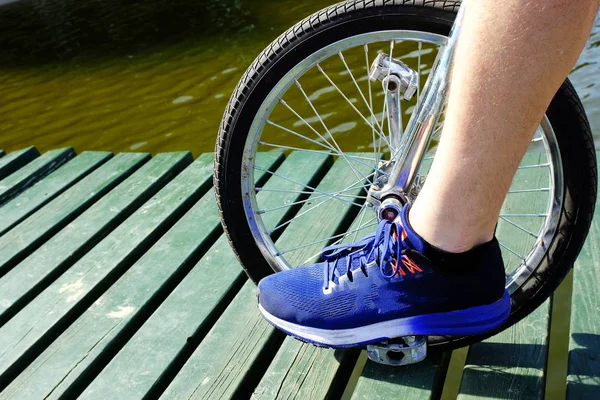 Homem montando uma unibike em um cais em um lago — Fotografia de Stock