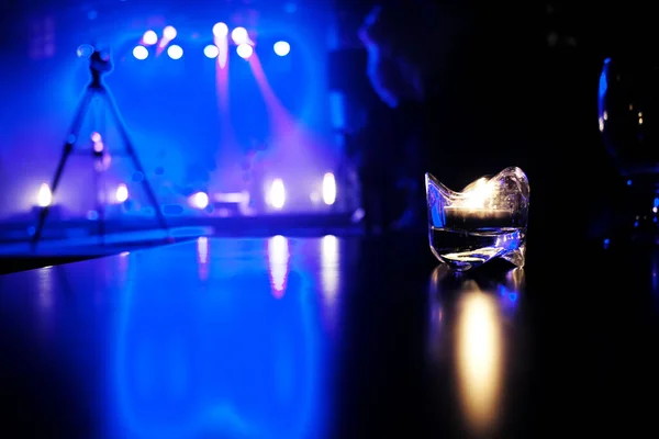 candle lit on a table in a cafe with blue lit stage in the background.Waiting for a concert on a cold september evening.