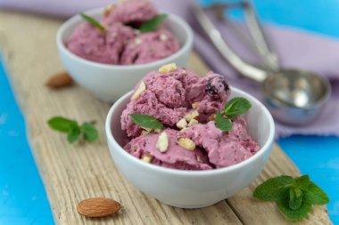 Çilekli dondurma. Fındık ve nane ile beyaz bir kapta dondurma topları.