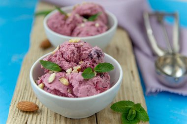 Çilekli dondurma. Fındık ve nane ile beyaz bir kapta dondurma topları.