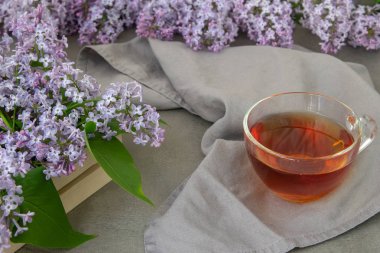 Leylak ve yapraklarıbahar çiçekleri, bir fincan çay. Dekoratif çerçeve, kopyalama alanı, üst görünüm.