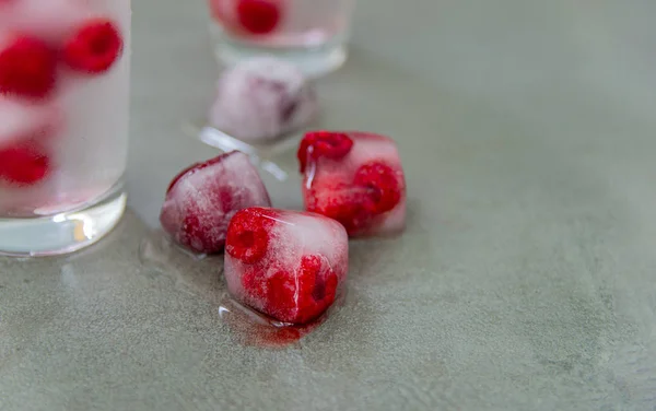 Summer raspberry drink with ice. Berry drink with fresh raspberries, ice lemonade in a glass.Copy space.