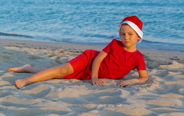 Ein Kind Mit Roter Weihnachtsmütze Spielt Auf Dem Meer Weihnachtsmann — Stockfoto
