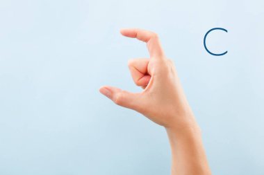 Fingerspelling alfabesi. Sağır ve dilsiz Bsl Alfabe harf C gösterilen mavi arka plan üzerinde izole eller.