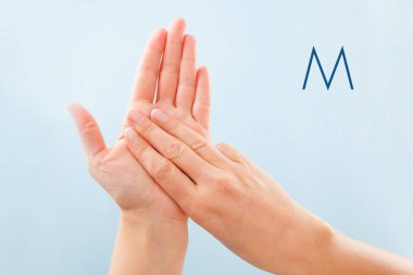 Fingerspelling alfabesi. Sağır ve dilsiz Bsl Alfabe harf M gösterilen mavi arka plan üzerinde izole eller.