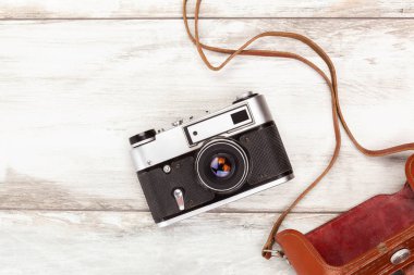 Vintage fotoğraf makinesi ile yukarıdan ahşap masa üzerinde eski deri çanta.