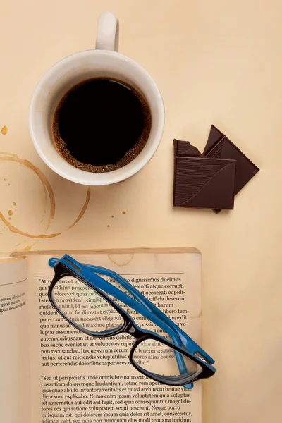 Xícara Café Óculos Leitura Pedaço Chocolate Livro Velho Mesa Bege — Fotografia de Stock