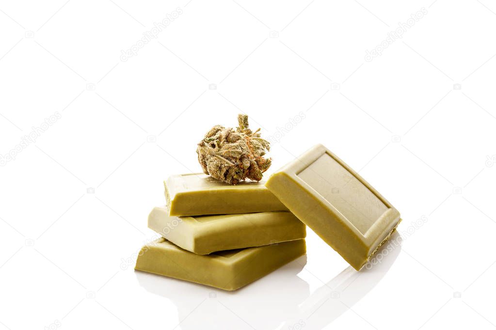 Marijuana chocolate blocks with ganja bud isolated on white background.