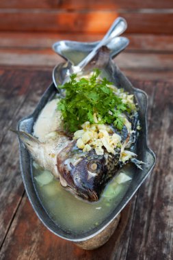 Taze ot ve sarımsak ile balık buğulama. Geleneksel Tayland mutfağı.